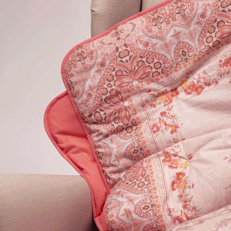 Scaldotto Giardino d'Inverno di Caleffi, in cotone caldo con stampa digitale. Fantasia floreale rosa bordeaux. Lo Scaldotto è un morbido plaid con esterno in cotone smerigliato effetto cashmere, che offre una sensazione di morbidezza e comfort sulla pelle