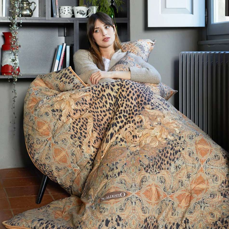 Scaldotto Panthere di Caleffi, in cotone caldo con stampa digitale. Fantasia leopardata e kashmir, variante naturale. Lo Scaldotto è un morbido plaid con esterno in cotone smerigliato effetto cashmere, che offre una sensazione di morbidezza e comfort sulla pelle. Imbottito con morbida microfibra anallergica SOFY da 250 g/mq, che assicura un'uniforme distribuzione del calore